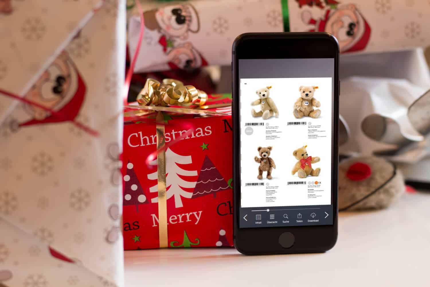 Weihnachtskatalog ePaper auf Smartphone vor Weihnachtsgeschenken